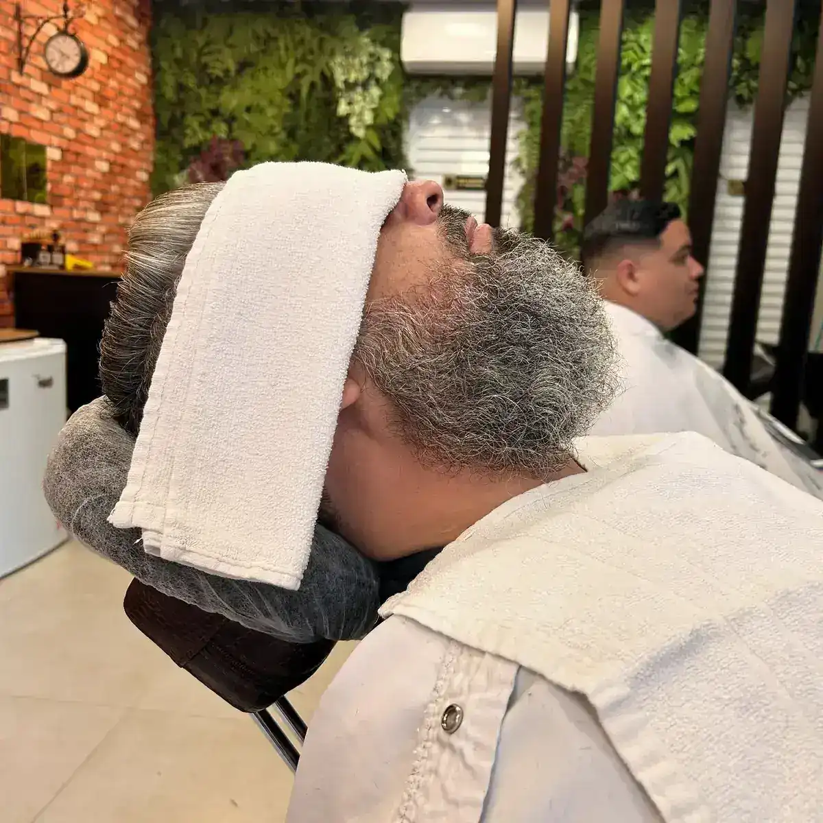 Atendimento de barboterapia com toalha quente na Peaky Barbers