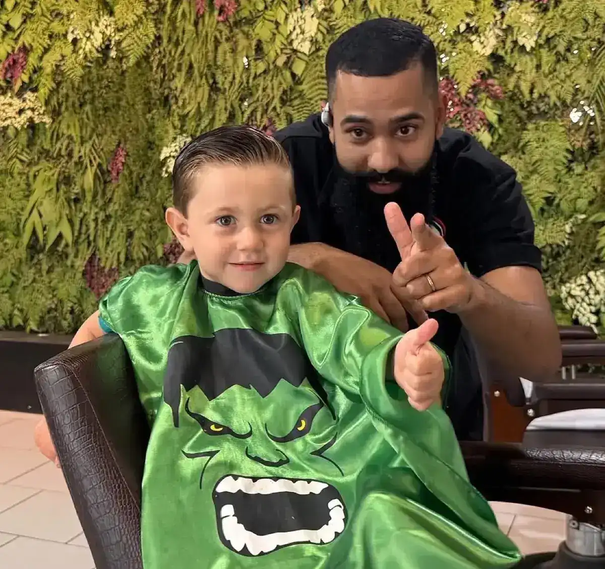 Criança com capa do Hulk após corte infantil na Peaky Barbers